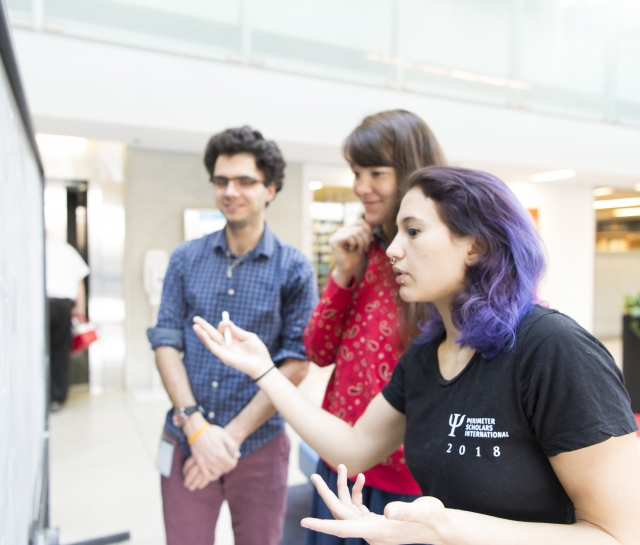 3 PSI students 2018 interacting if front of a blackboard in the atrium