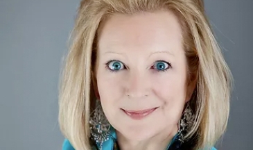 Portrait of a woman with blonde hair in a bright blue blazer