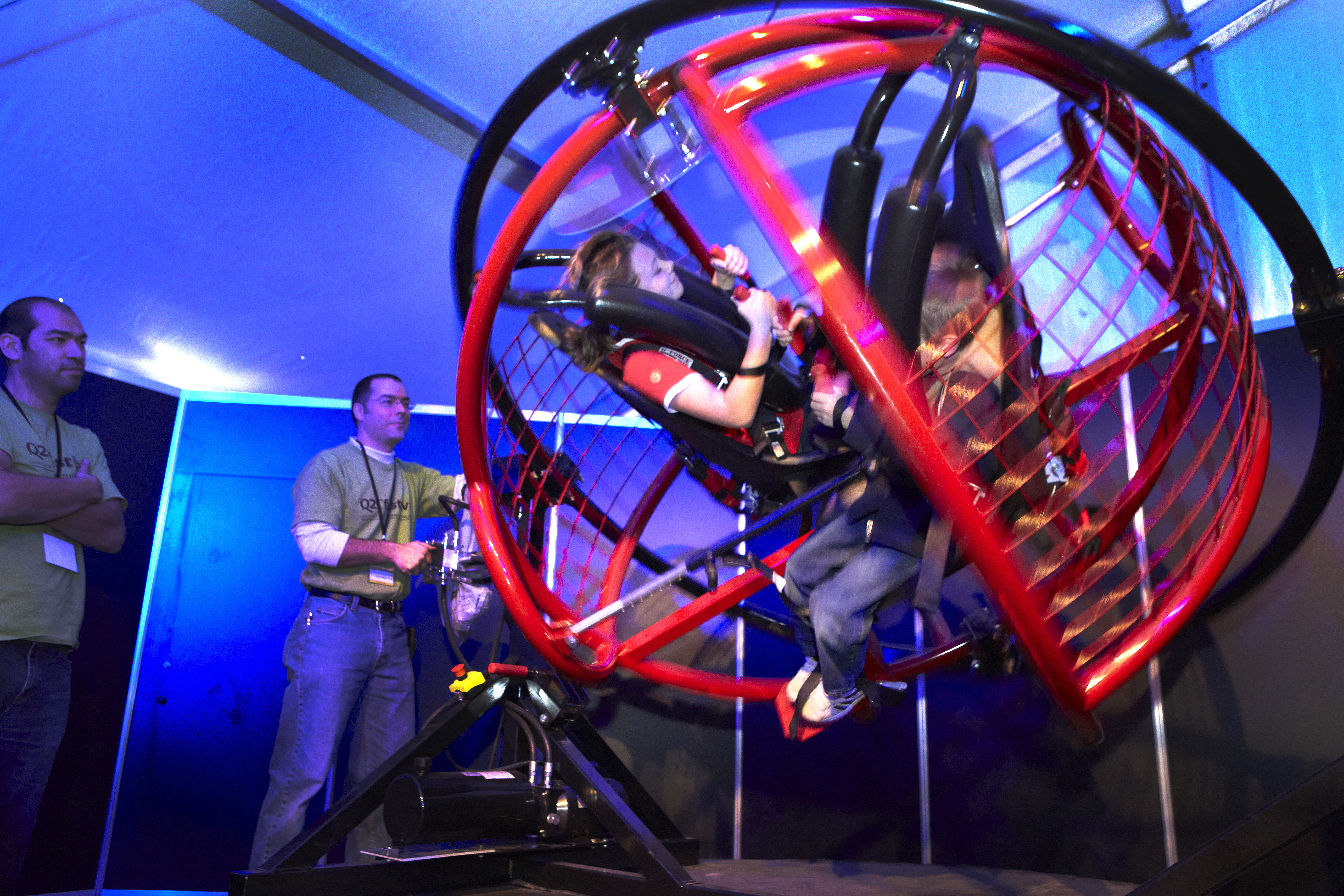 Two people riding around in a ride shaped like a sphere