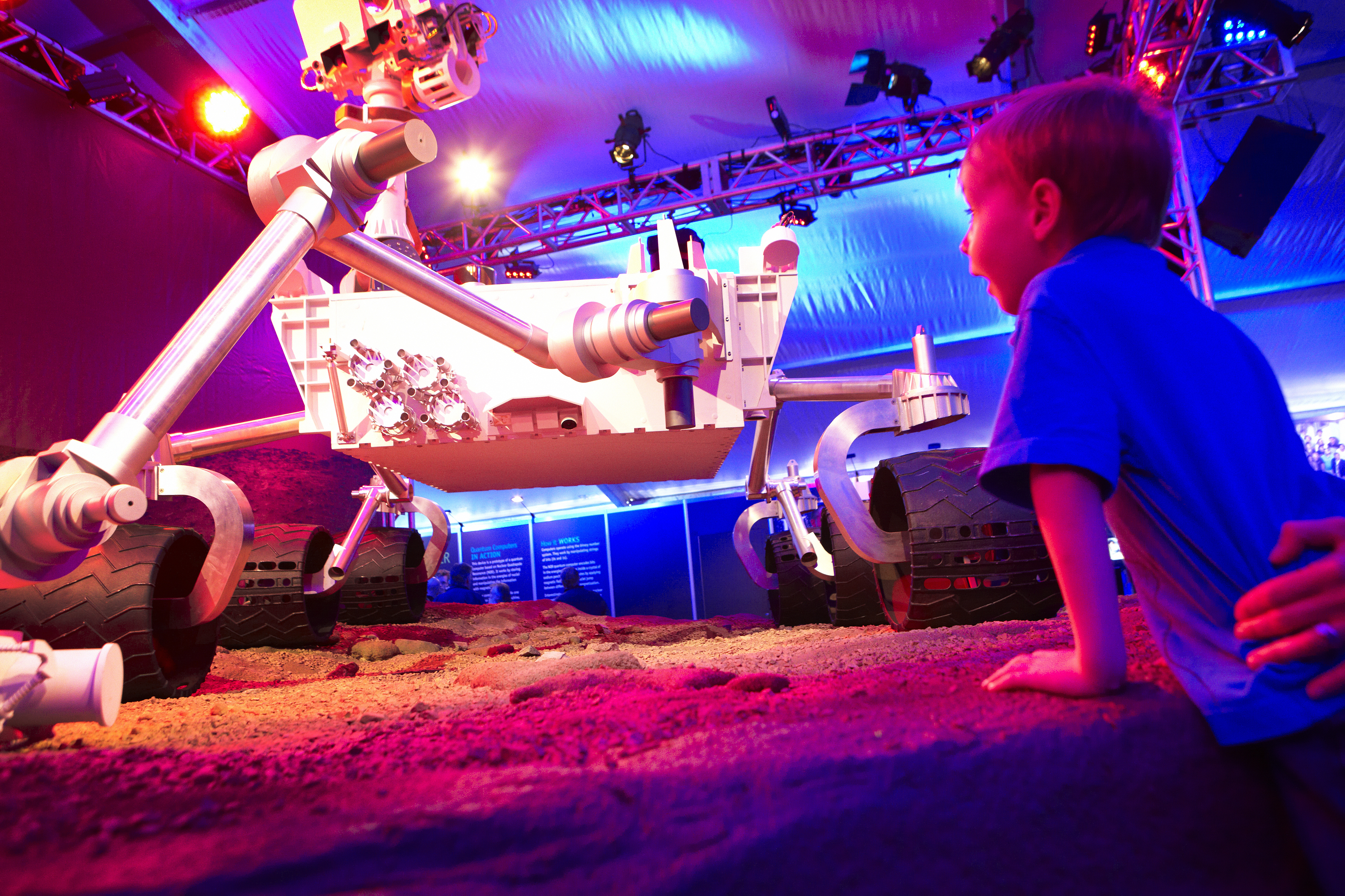 A young boy looking at a robot at a science festival