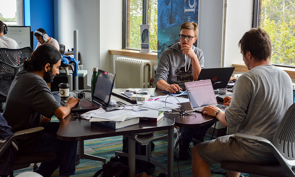 Group of men working together at a table with their computers