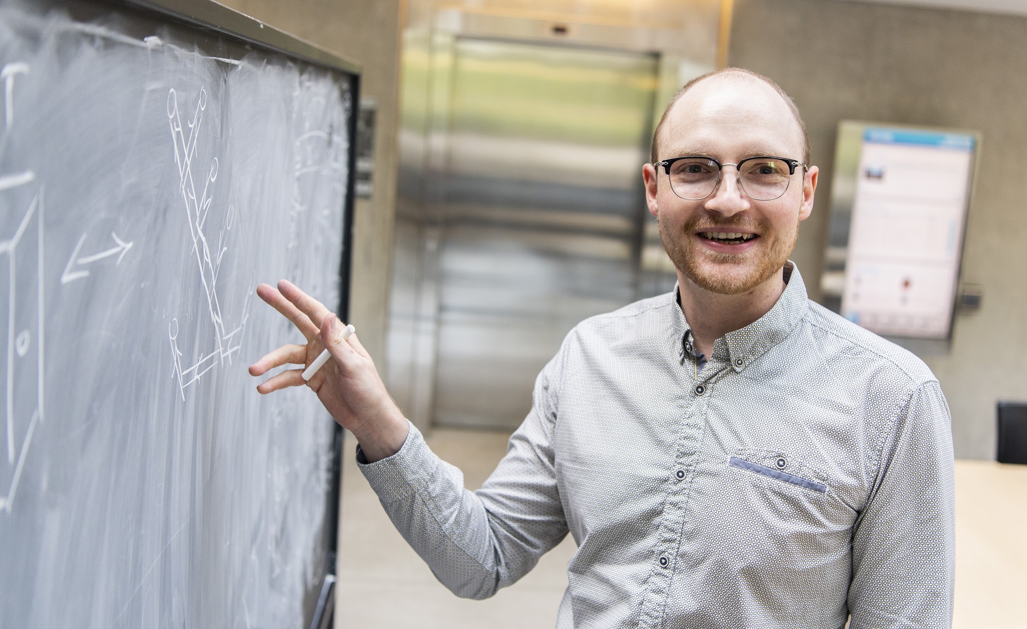 Perimeter Institute postdoc Sebastian Steinhaus talking in front of a blackboard