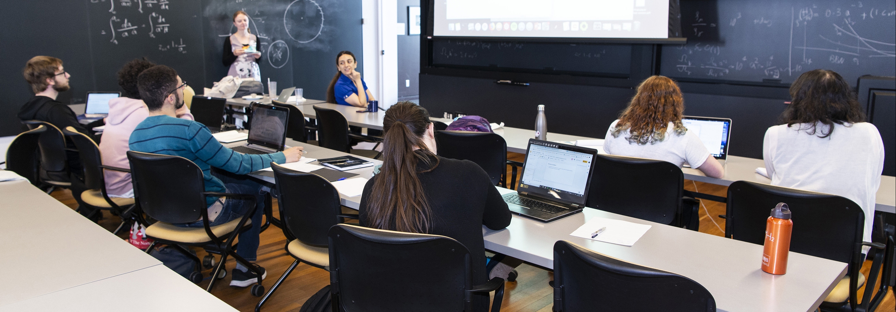 Students sitting classroom style in lecture room listening to teaching