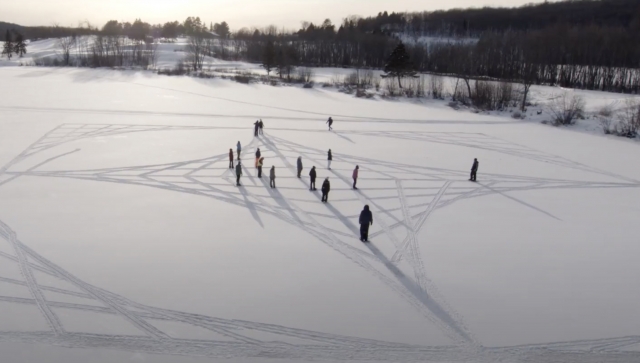 Students making symbols in a field of snow