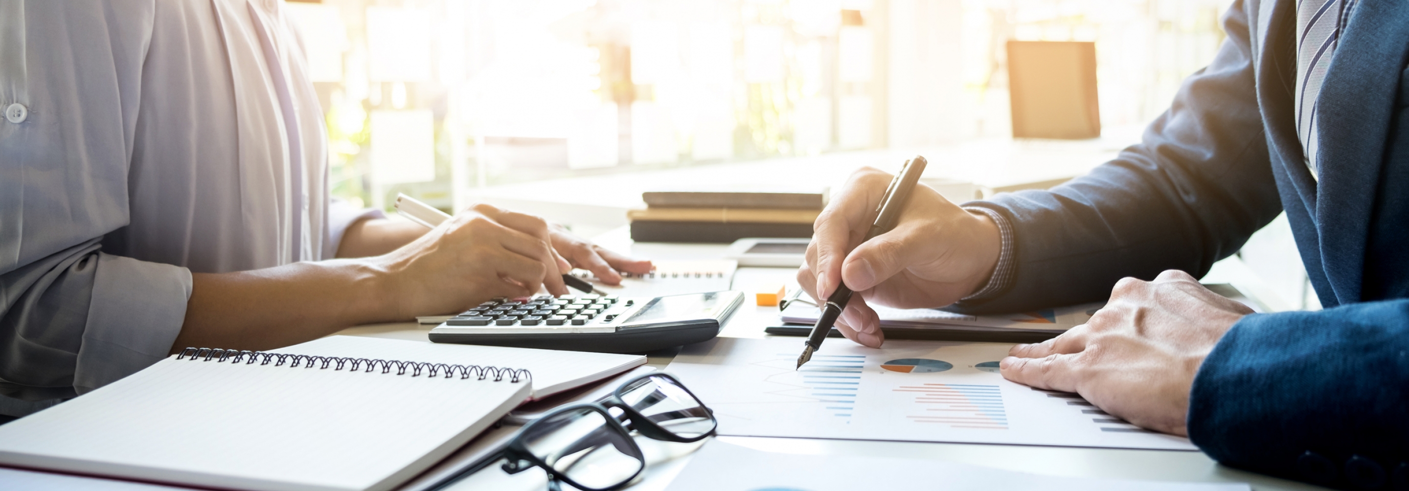 Woman and man sitting at table together working on financial statements