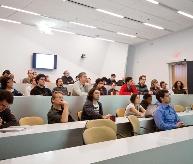 People sitting in a lecture room listening to a presentation